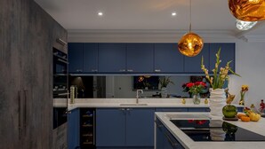 A modern kitchen with dark blue cabinets, a white countertop, and a central island. - Luxury Apartment in 18th century listed Hotel conversion (Farnham)