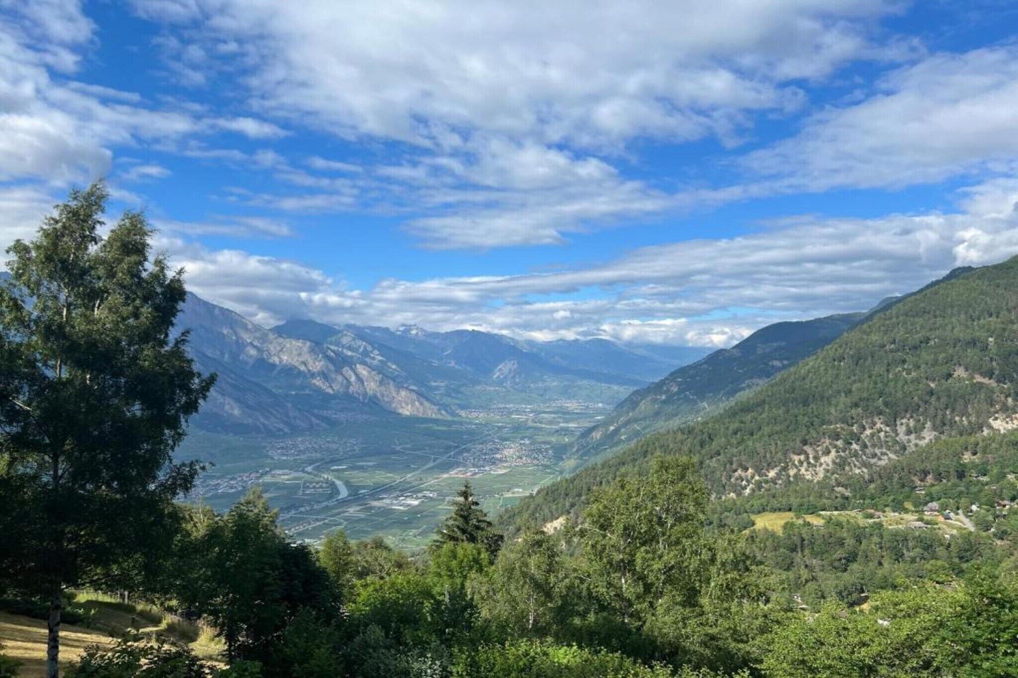 Eine Berglandschaft mit einem Tal und einer Stadt in der Ferne.