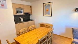 A compact kitchen with a microwave, a kettle, and a framed poster on the wall. - Apartment near Piste de Tracouet (Haute-Nendaz)