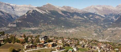 A mountain village with houses and a winding road.