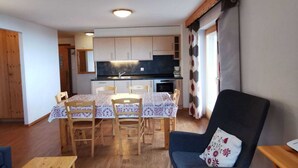Un espai vital compacte amb zona de menjador, cuina americana i zona d'estar.