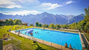 Una piscina con vistas a montañas al fondo.