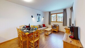 A compact living space with a dining area, a sofa, a small table, and a coffee machine. - Apartment in Nendaz near Cable Car (Haute-Nendaz)
