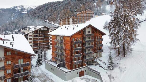 A snow-covered mountain resort with wooden buildings and balconies. - Apartment in Nendaz near Cable Car (Haute-Nendaz)