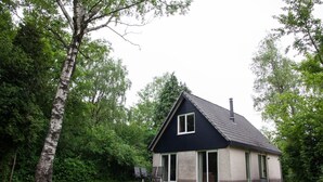 A single-story house with a dark roof and light walls, surrounded by a grassy yard and trees. - Retreat in Scherpenzeel for Couples (Scherpenzeel)