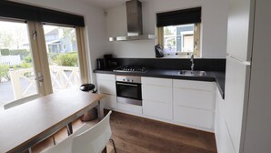 Una cucina compatta con piano cottura a gas, forno e finestra vista esterna.
