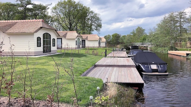 Una propiedad junto al canal, con una casa y un muelle cubierto.