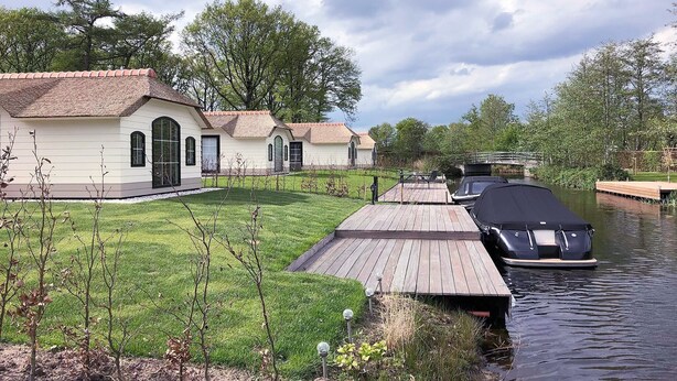 Une propriété située au bord d’un canal, comprenant une maison et un quai abrité.