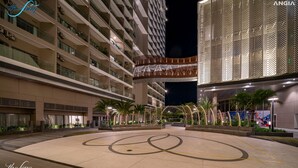 Een modern hotel met meerdere verdiepingen, buiten zitplekken en een decoratieve gevel.