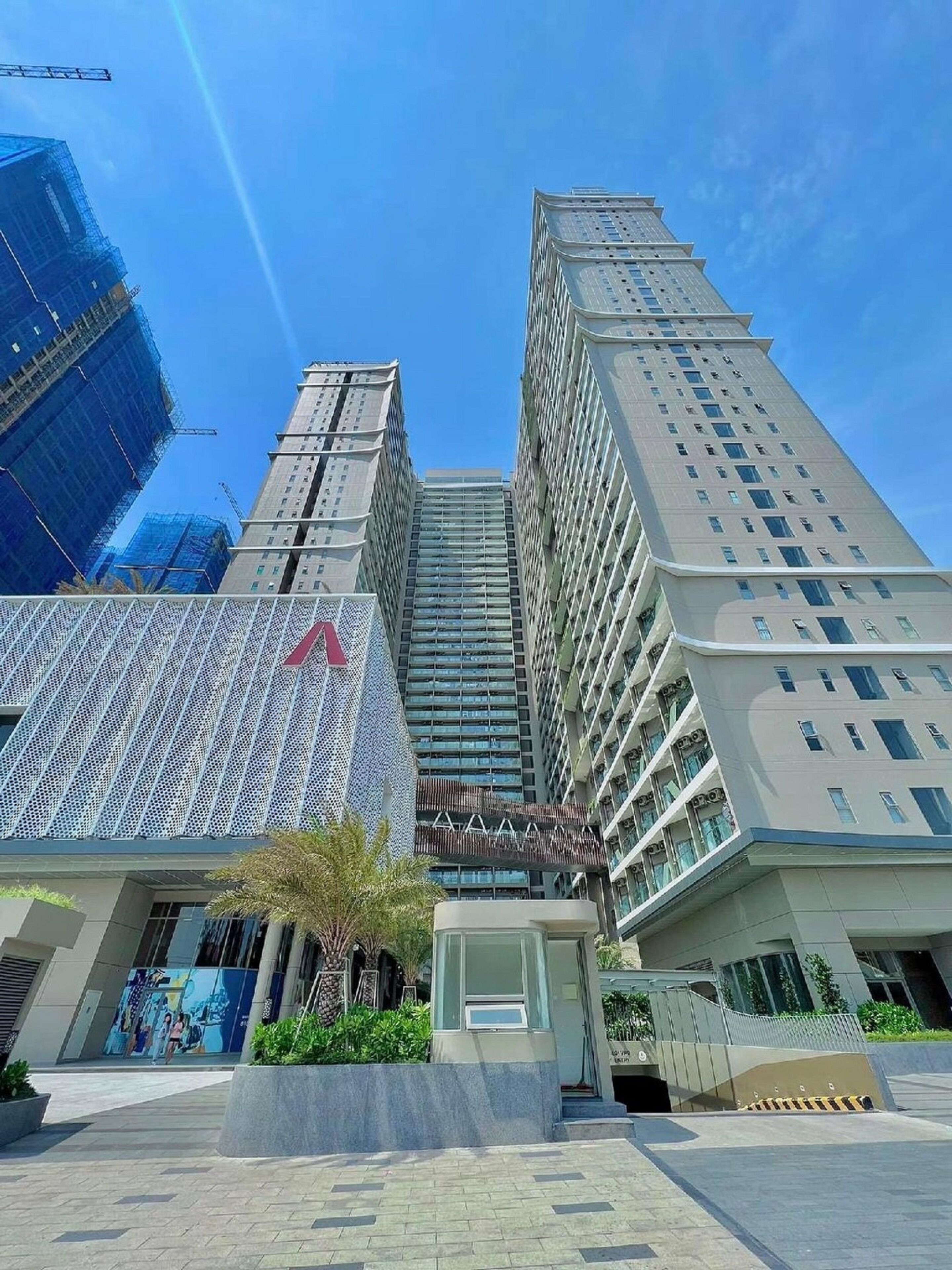 A modern high-rise building with a distinctive geometric facade, surrounded by other tall buildings.