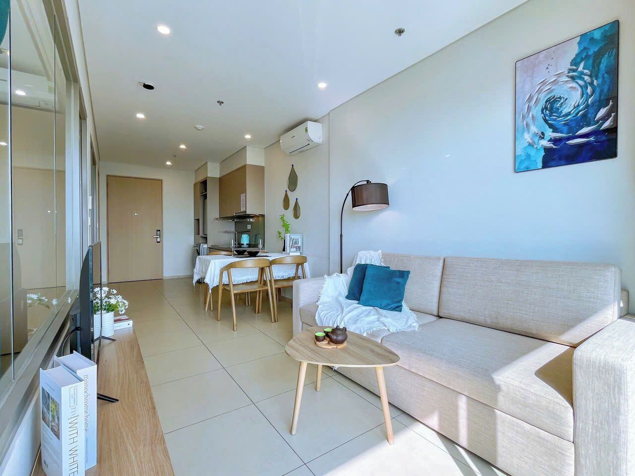 Una sala de estar moderna con un sofá, una mesa de centro y un comedor con una mesa y sillas.