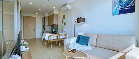 Una sala de estar moderna con un sofá, una mesa de centro y un comedor con una mesa y sillas.