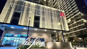 Een modern hotel met een opvallende gevel, gekenmerkt door verticale lijnen en een grote rode vlag.