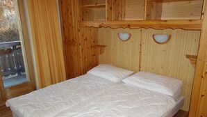 A wooden room with a bed, a window, and a wooden railing outside. - Pleasant apartment with sauna (Haute-Nendaz)