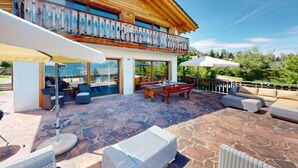 A wooden chalet with a balcony, stone patio, outdoor seating, and a view of the mountains. - Tranquil chalet with balcony (Haute-Nendaz)