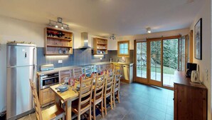 A modern kitchen with a dining area, built-in shelves, a large window, and a view of the outdoors. - Chalet in Nendaz near Ski Slopes (Haute-Nendaz)