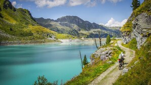 A mountain path with a cyclist, a lake, and mountains in the background. - Chalet in Nendaz near Ski Slopes (Haute-Nendaz)