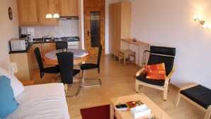 A compact living space with a kitchenette, a dining area, and a seating area with a chair and a small table. - Studio in Nendaz near Ski Lift (Haute-Nendaz)