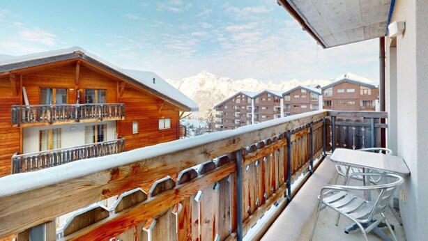 A wooden chalet with a balcony, a table, and chairs. - Appealing apartment with balcony (Haute-Nendaz)