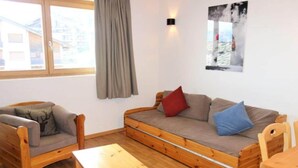 A cozy room with a wooden sofa, a wooden chair, and a small wooden table. - Amazing apartment with terrace (Haute-Nendaz)
