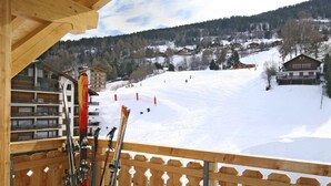 Et skiområde med træhuse, stolelift og en snedækket piste.