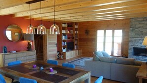 Una sala de estar acogedora con chimenea, muebles de madera y una estantería.