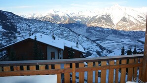 A wooden cabin with a snow-covered roof, surrounded by a mountainous landscape with snow-covered peaks. - Apartment for 8 in Veysonnaz (Veysonnaz)