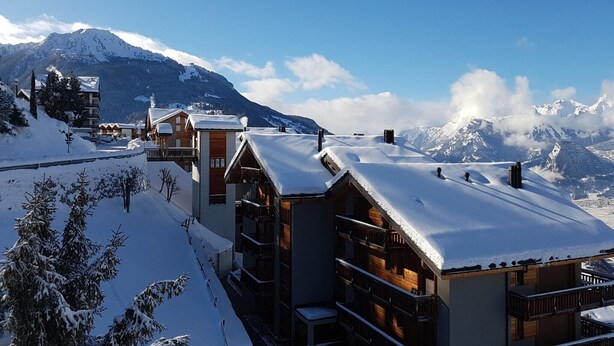 A snow-covered mountain resort with wooden buildings and a clear sky. - Apartment for 8 in Veysonnaz (Veysonnaz)