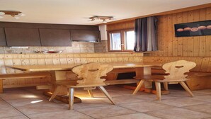 A kitchen with wooden cabinets, a large wooden table, and chairs. - Apartment for 8 in Veysonnaz (Veysonnaz)