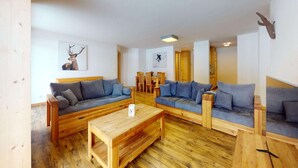 Un salon chaleureux, avec des meubles en bois et une tête de cerf accrochée au mur.