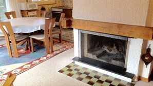 Una sala de estar acogedora con chimenea, muebles de madera y una alfombra estampada.