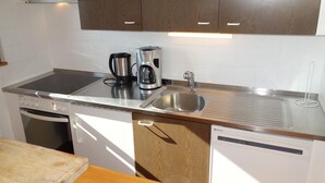 Eine moderne Küche mit Einbauofen, Kaffeemaschine und Geschirrspüler.