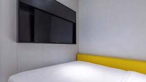 A room with a bed, a headboard, and a mounted TV. - yibaijiudianlangaoluditiezhandian (Shanghai)