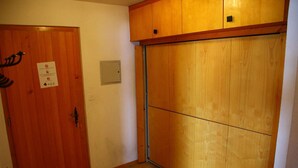 A room with a wooden door, a cabinet, and a tiled floor. - Apartment, 250m from cable car (Veysonnaz)