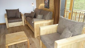 Un salon meublé de meubles en bois, avec deux canapés et une petite table en bois.