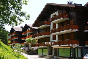 Un hotel de varios pisos con balcones, fachada de piedra y un letrero que indica disponibilidad.