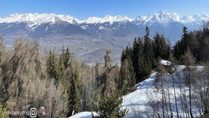 A mountainous landscape with snow-covered peaks and dense forest. - Marvelous apartment with balcony (Les Agettes)