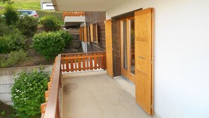 Un balcon doté de balustrades en bois et d’une porte en bois.