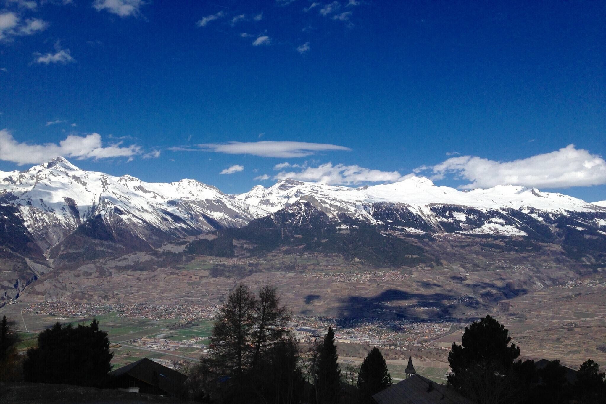 Eine gebirgige Landschaft mit schneebedeckten Gipfeln und einem Tal.