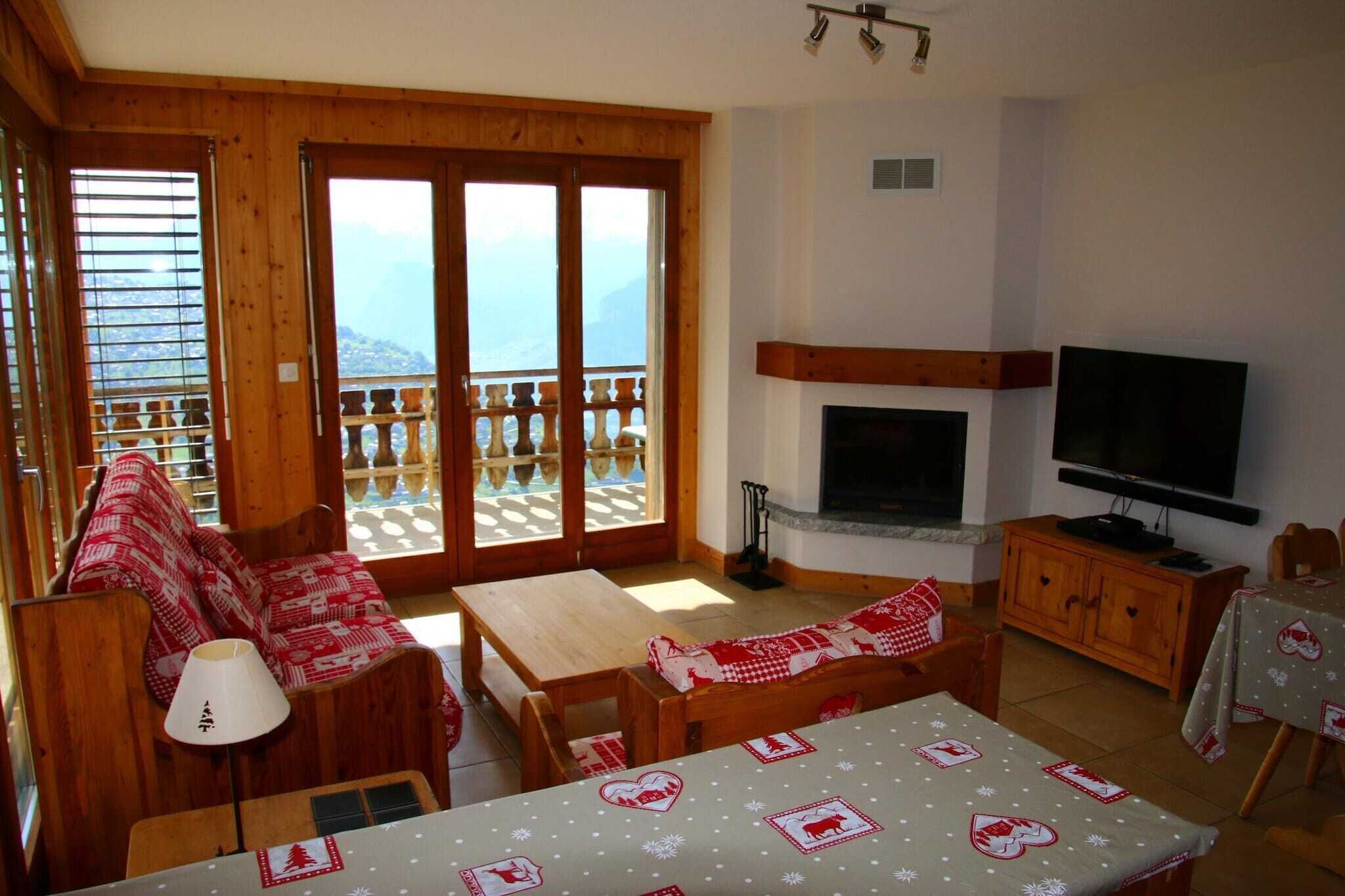 Een gezellige woonkamer met houten meubels, een open haard, een televisie en een balkon met een prachtig uitzicht.
