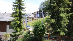 A residential area with a house, a car, and a building with a ski lift. - Apartment near Cable Car with Valley Views (Veysonnaz)