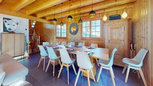 Een houten interieur met een eettafel voor zes personen, omringd door zes stoelen.