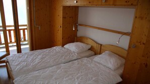 Une pièce en bois avec un lit, une petite table et une fenêtre donnant sur un beau paysage.