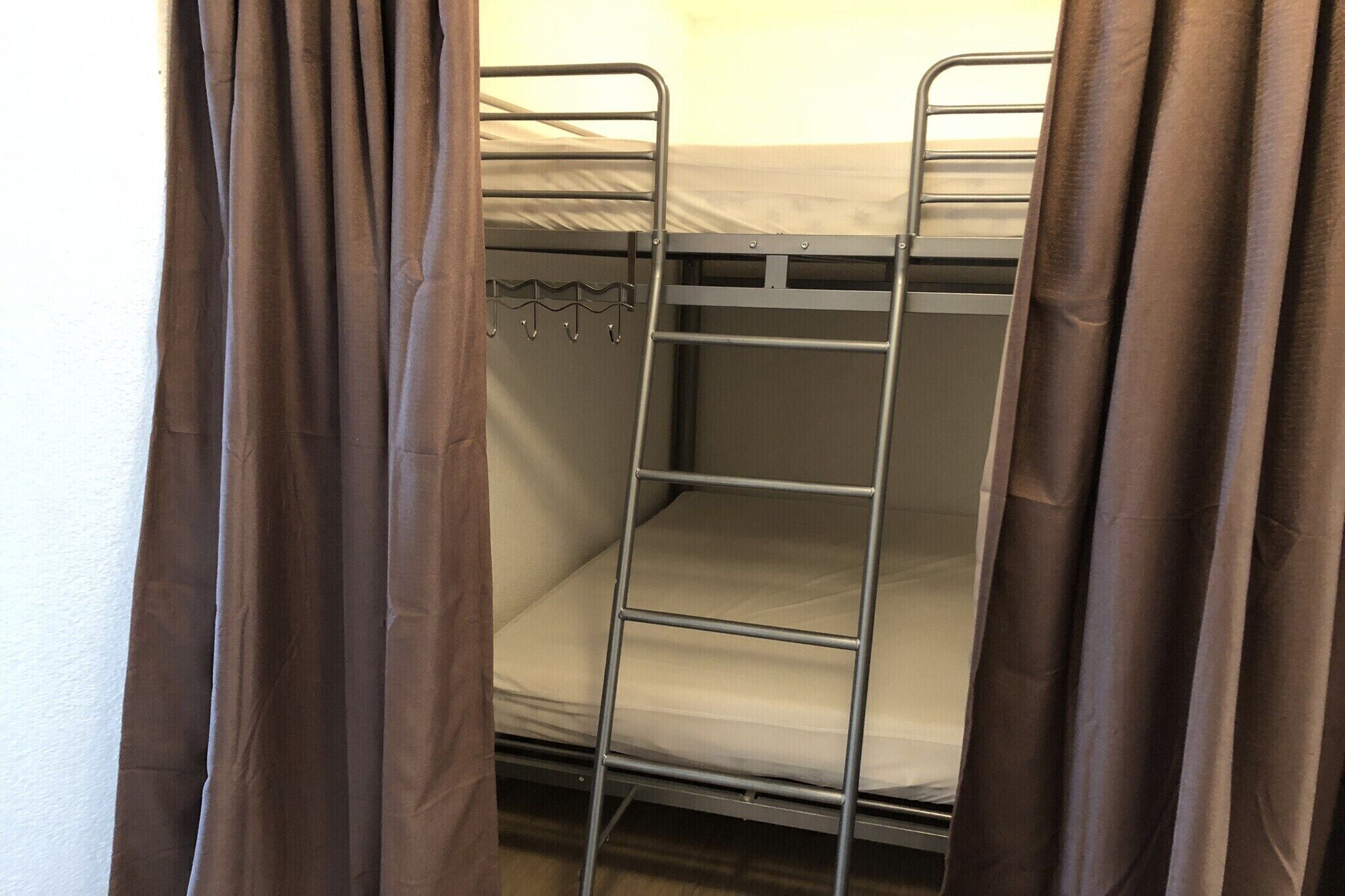 Un letto a castello con ringhiere in metallo e un gancio singolo.