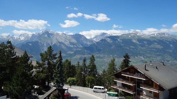 A mountain lodge with a balcony and a view of snow-capped peaks. - Centrally-located apartment in Veysonnaz (Valais)
