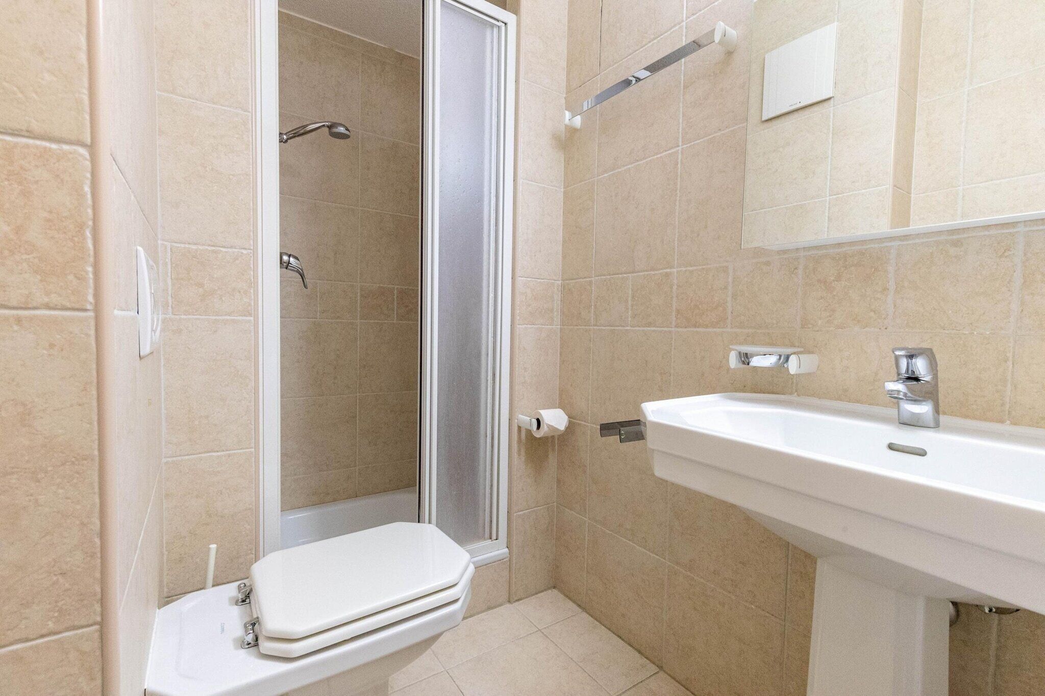 A bathroom with a shower, toilet, and sink.