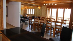 A wooden interior with a dining area, a bar, and a seating area with a view. - Chalet in Veysonnaz with mountain view (Veysonnaz)