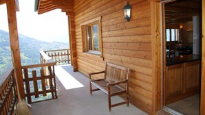 A wooden cabin with a balcony, a wooden bench, and a window. - Chalet in Veysonnaz with mountain view (Veysonnaz)