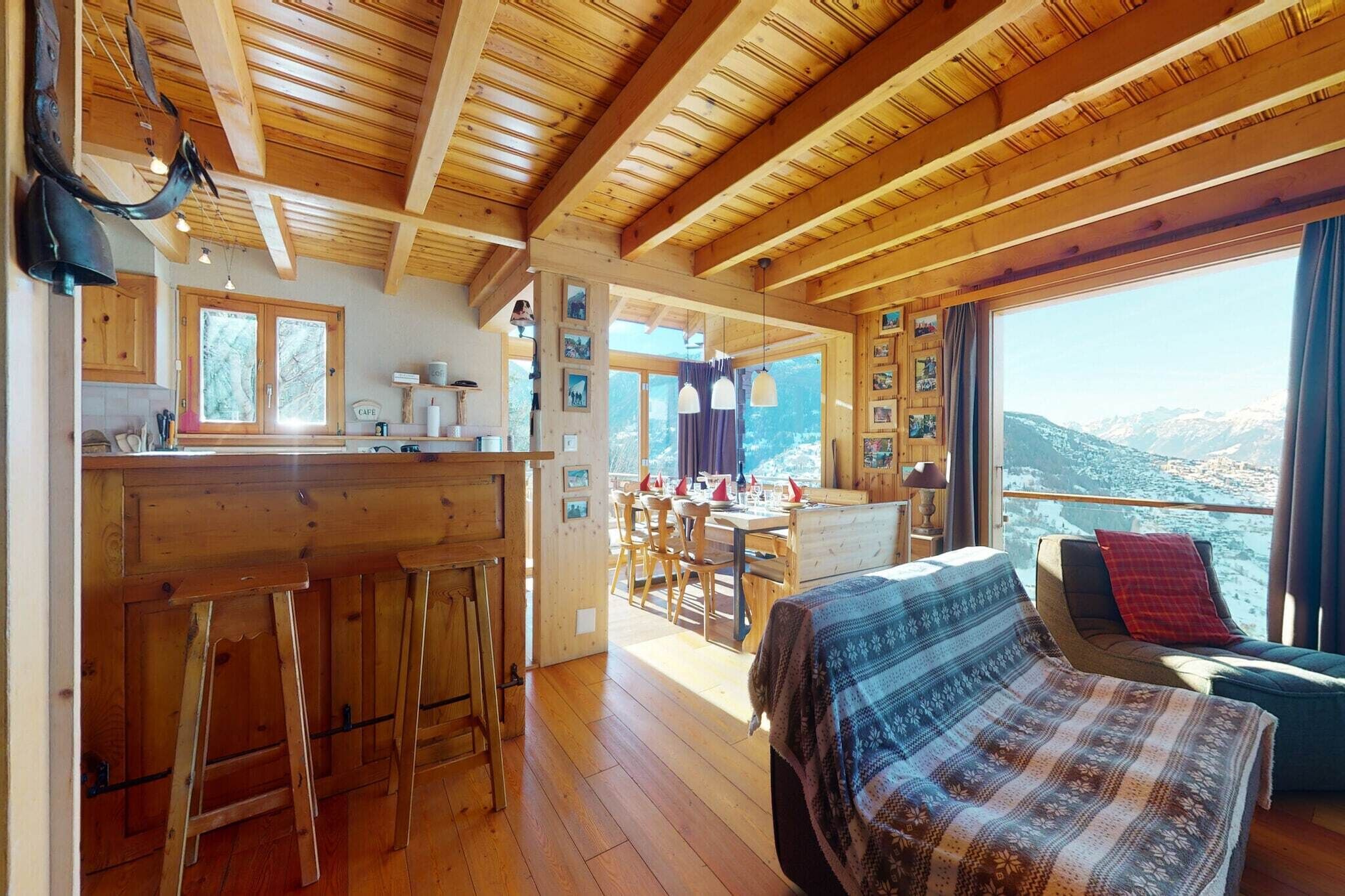 Un interior de madera con cocina, comedor y una cama con vistas.