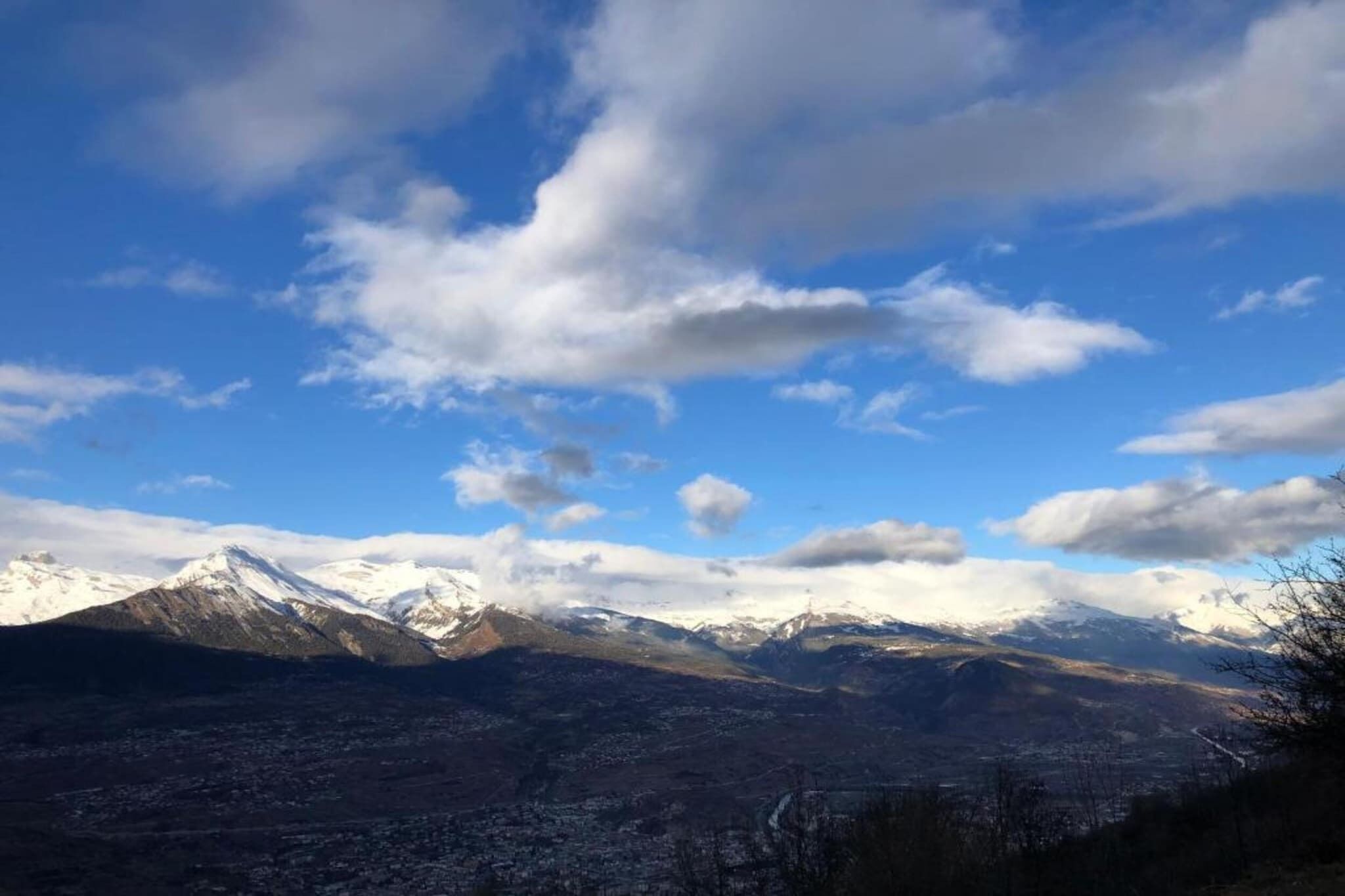 Eine Berglandschaft mit schneebedeckten Gipfeln und blauem Himmel.